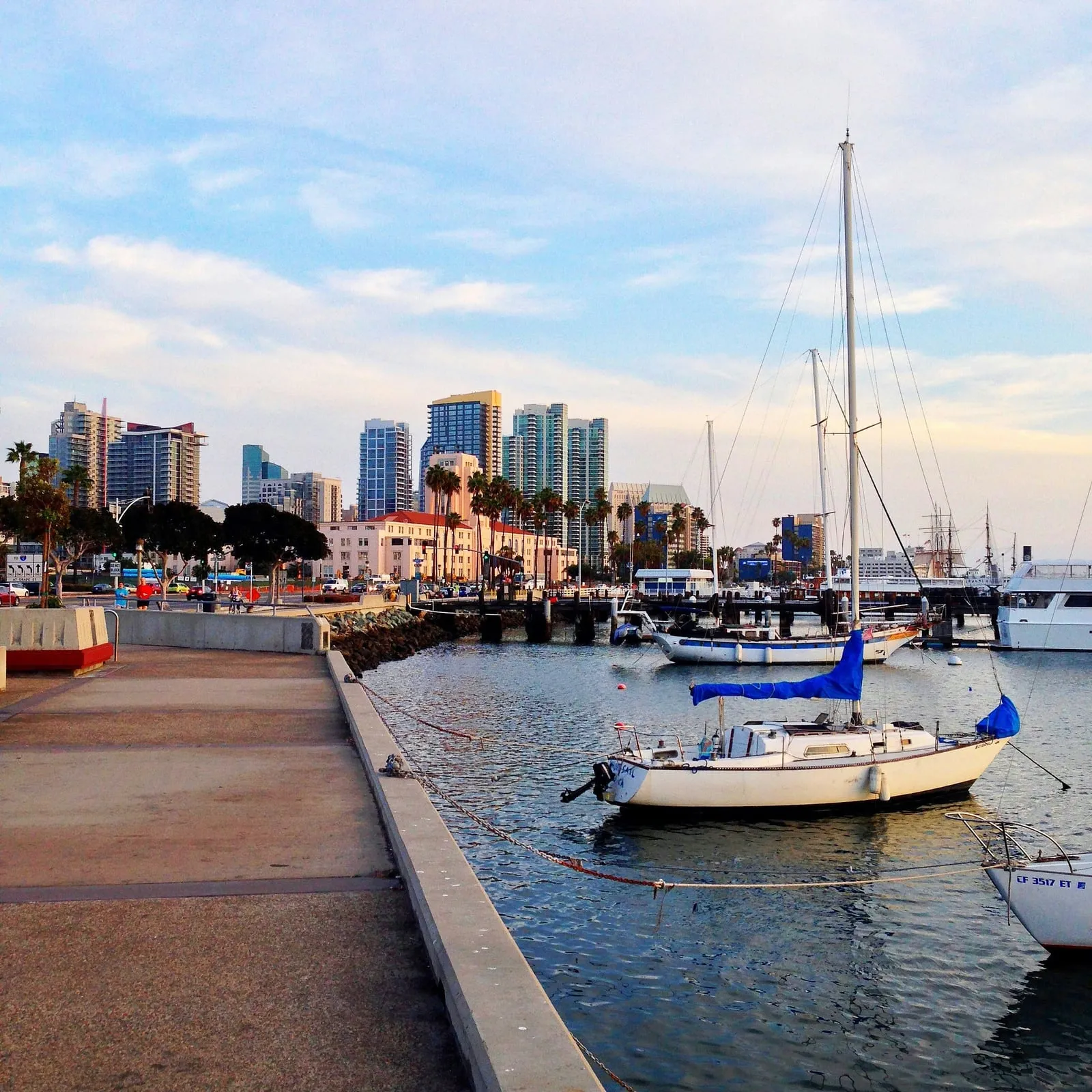 Sailboats moored along the San Diego waterfront, with the downtown skyline behind them.